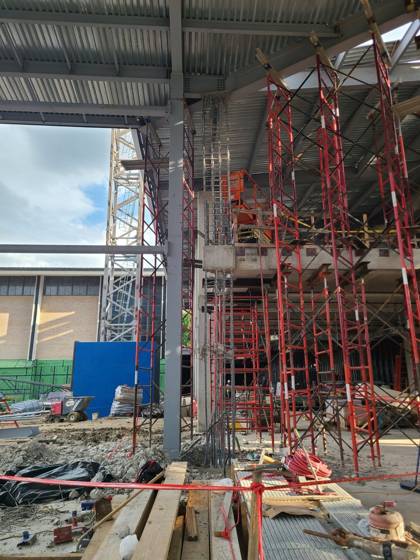 Column demolition while shoring supports the elevated slab and steel roof
